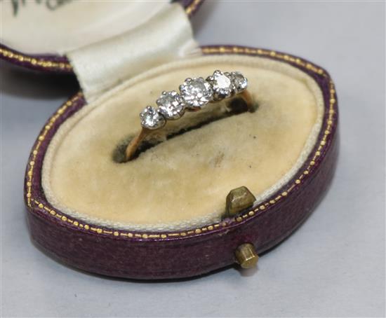 An early 20th century yellow metal and graduated five stone diamond ring size M.